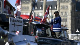 Demonstrant in Ottawa befestigt eine mit Gitterstäben geschmückte Fahne auf seinem Lkw - Aufschrift: "Trudeaus neues Zuhause".
