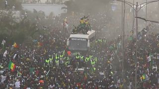 The bus transporting Senegal's football team in the streets of Dakar, surrounded by a crowd 
