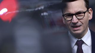 Poland's Prime Minister Mateusz Morawiecki speaks with the media as he arrives for an EU Summit at the European Council building in Brussels, Thursday, Dec. 16, 2021