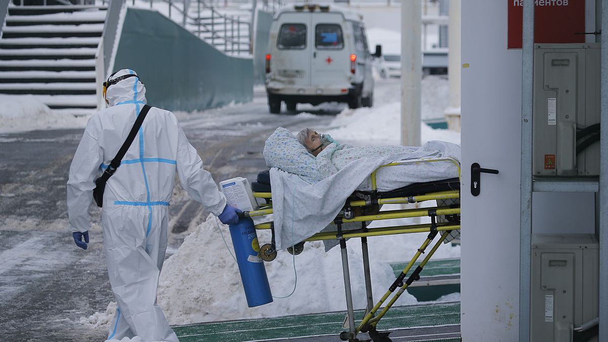 Medical workers carry a patient suspected of having coronavirus on a stretcher at a hospital in Kommunarka, outside Moscow, Russia, Saturday, Jan. 29, 2022.
