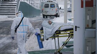 Medical workers carry a patient suspected of having coronavirus on a stretcher at a hospital in Kommunarka, outside Moscow, Russia, Saturday, Jan. 29, 2022.