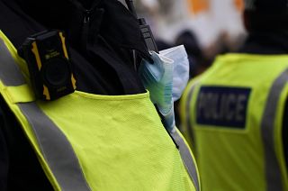 A police officers stands outside Downing Street during an anti-vaccine protest in London.