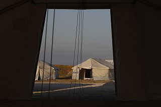 A migrant sits inside a tent at the new temporary refugee camp at Karatepe, near Mytilene town, on the northeastern island of Lesbos