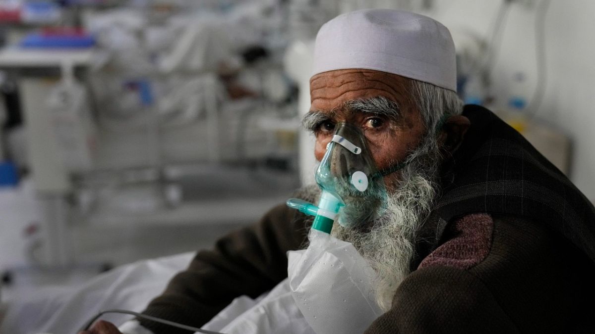 An Afghan patient infected with COVID-19 sits on a bed in the intensive care unit of the Afghan Japan Communicable Disease Hospital, Kabul, Afghanistan, Monday, Feb. 7, 2022.