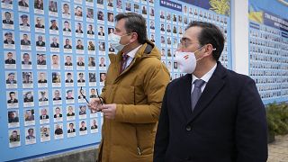 Der ukrainische Außenminister Dmytro Kuleba und sein spanischer Amtskollege Jose Manuel Albares vor einer Gedenkmauer für Gefallene im Konflikt mit Russland