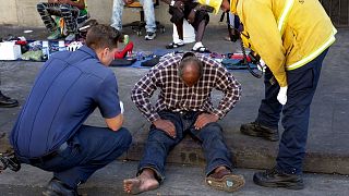 کمک امدادگران به یک بی‌خانمان در یکی از محله‌های لس‌آنجلس