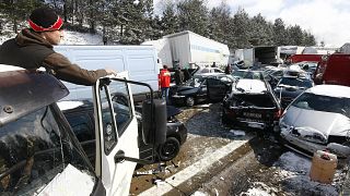 A man looks on crashed cars on the Czech D1 motorway between Prague and Brno where tens of vehicles collided in a series of crashes in a snowstorm on 20 March, 2008