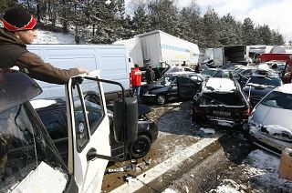 A man looks on crashed cars on the Czech D1 motorway between Prague and Brno where tens of vehicles collided in a series of crashes in a snowstorm on 20 March, 2008