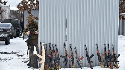 A military instructor looks at at Kalashnikov rifles and wooden replicas prior to a training session at an abandoned factory in the Ukrainian capital of Kyiv on February 6.