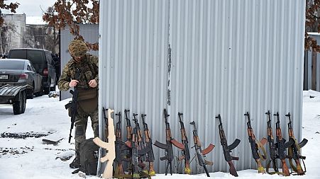 A military instructor looks at at Kalashnikov rifles and wooden replicas prior to a training session at an abandoned factory in the Ukrainian capital of Kyiv on February 6.