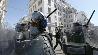 افراد من الشرطة الجزائرية يشهرون هراواتهم خلال مظاهرة في الجزائر - أرشيف