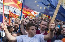 People waving national and EU flags gather at a rally in Skopje, April 2019