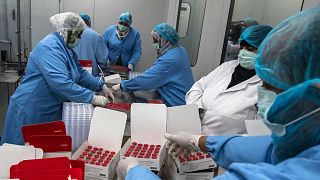 عمال المختبر يملأون الصناديق بقوارير من لقاح سينوفاك الصيني ضد فيروس كورونا، الذي تنتجه شركة فاكسيرا المصرية بالعاصمة القاهرة، 1 سبتمبر 2021