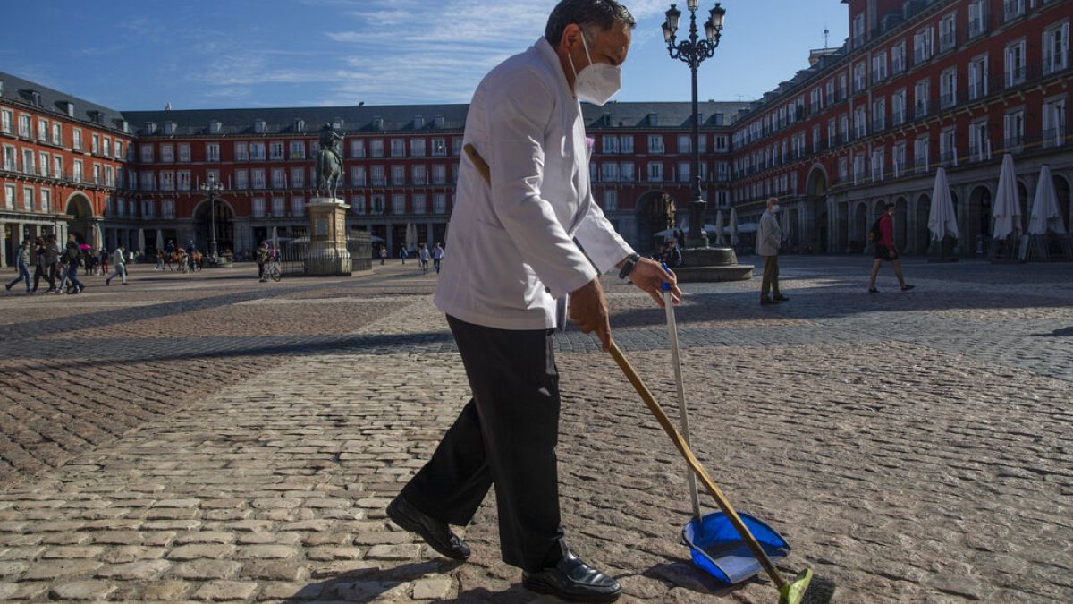 Σερβιτόρος σκουπίζει σε ανοιχτό χώρο στο κέντρο της Μαδρίτης