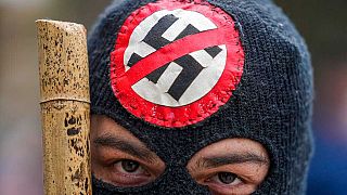 Nazi karşıtı sembol taşıyan maske giyen bir gösterici (Arşiv)