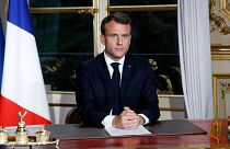 French President Emmanuel Macron sits at his desk after addressing the French nation at the Elysée Palace in Paris, 2019.