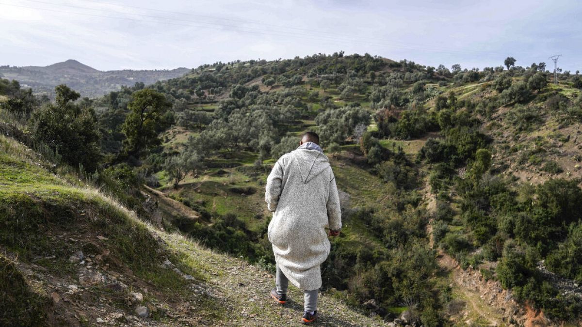 رجل يسير عبر تلة بقرية إيغران خلال مهمة إنقاذ ريان، البالغ من العمر خمس سنوات، بعد أن سقط في بئر عميق، ضواحي شفشاون، شمالي المغرب، الجمعة 4 فبراير 2022. 