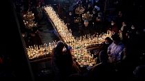 شاهد: مصلون يُشكلون صليبا بعبوات العسل المضاءة احتفالا بـ"رب جميع الأمراض" في بلغاريا