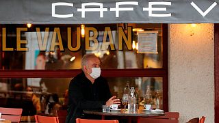 A man wearing mask sits on a cafe terrace in Saint Jean de Luz, southwestern France, Monday, Oct. 12, 2020