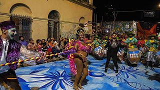 Bailarines y tamborileros de candombe actúan durante el desfile de carnaval "Las llamadas", 10/2/2022, Montevideo, Uruguay