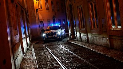 A police car drives through a narrow street of the old Alfama neighbourhood in Lisbon. A police car drives through a narrow street of the old Alfama neighbourhood in Lisbon.