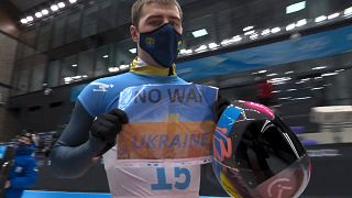 Vladyslav Heraskevych, of Ukraine, holds a sign that reads "No War in Ukraine" after a run at the men's skeleton competition at the 2022 Winter Olympics, Feb 11, 2022.