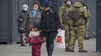 A woman holds a child's hand as they cross from Ukrainian government to pro-Russian separatists controlled territory in Stanytsia Luhanska. A woman holds a child's hand as they cross from Ukrainian government to pro-Russian separatists controlled territory in Stanytsia Luhanska.