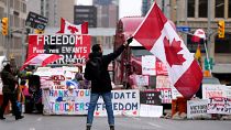Un manifestante agita una bandera en una protesta contra las medidas del COVID-19 que se ha convertido en una protesta más amplia contra el Gobierno, Ontario, el 11 febrero.