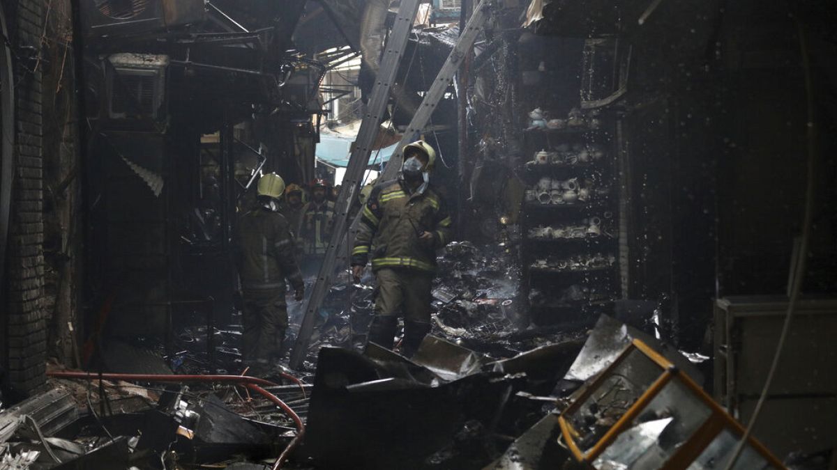 Πυροσβέστης επιθεωρεί τις ζημιές από τη φωτιά στο Μεγάλο Παζάρι της Τεχεράνης