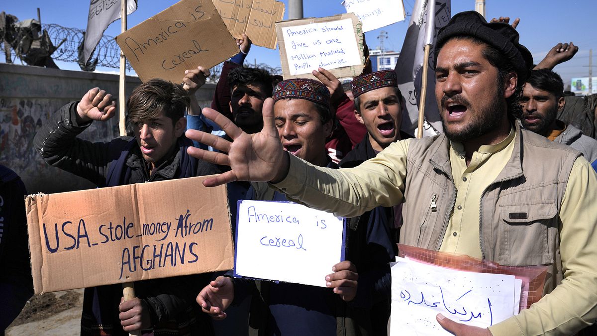 Afghan protesters hold placards and shout slogans during a protest condemning President Joe Biden's decision, in Kabul