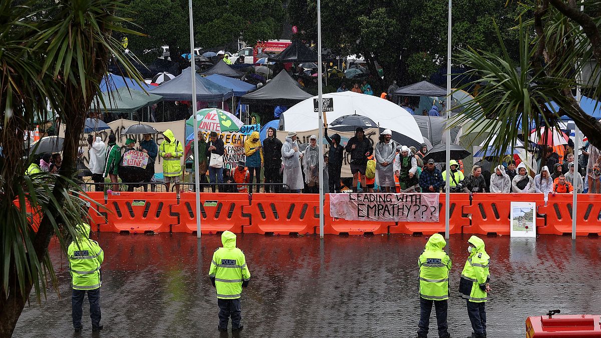 الشرطة تقف تحت المطر أثناء حراسة البرلمان في اليوم السادس من المظاهرات ضد قيود كوفيد-19 في ويلينغتون.
