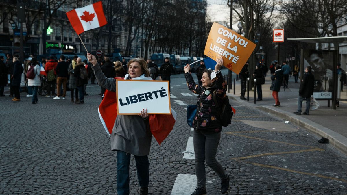 متظاهرون غاضبون يحملون لافتات كتب عليها "الحرية" و"قافلة الحرية" في مظاهرات في باريس، فرنسا، الجمعة 11 فبراير 2022. 
