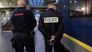 A French Border Police officer (L) and a National Police officer stand near an Eurostar train in Gare du Nord station in Paris on December 10, 2020.