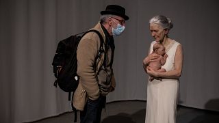 Un visiteur regarde l'oeuvre "Woman and Child" de Sam Jinks à l'exposition "Hyperrealisme. Ceci n'est pas un corps" à Lyon, France