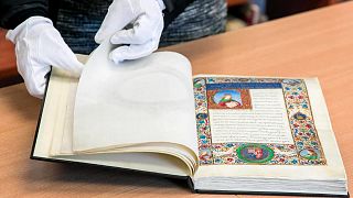 A librarian displays a unique 15th century ornamented manuscript on parchment in a library in Torun, Poland, on Monday, Feb. 14, 2022.