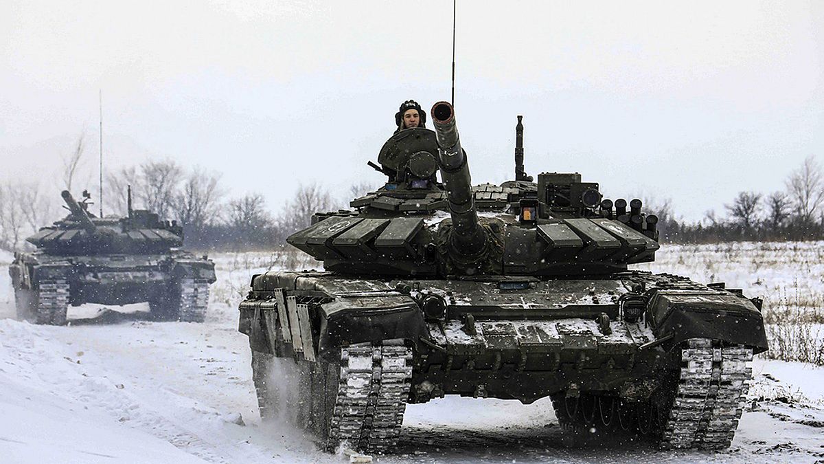 In this photo provided by the Russian Defense Ministry Press Service on Feb. 14, 2022, Russian tanks roll on the field during a military drills in Leningrad region, Russia.