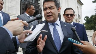 El entonces presidente de Honduras, Juan Orlando Hernández, responde preguntas a la prensa al salir de una reunión en la OEA en Washington, el 13 de agosto de 2019. 