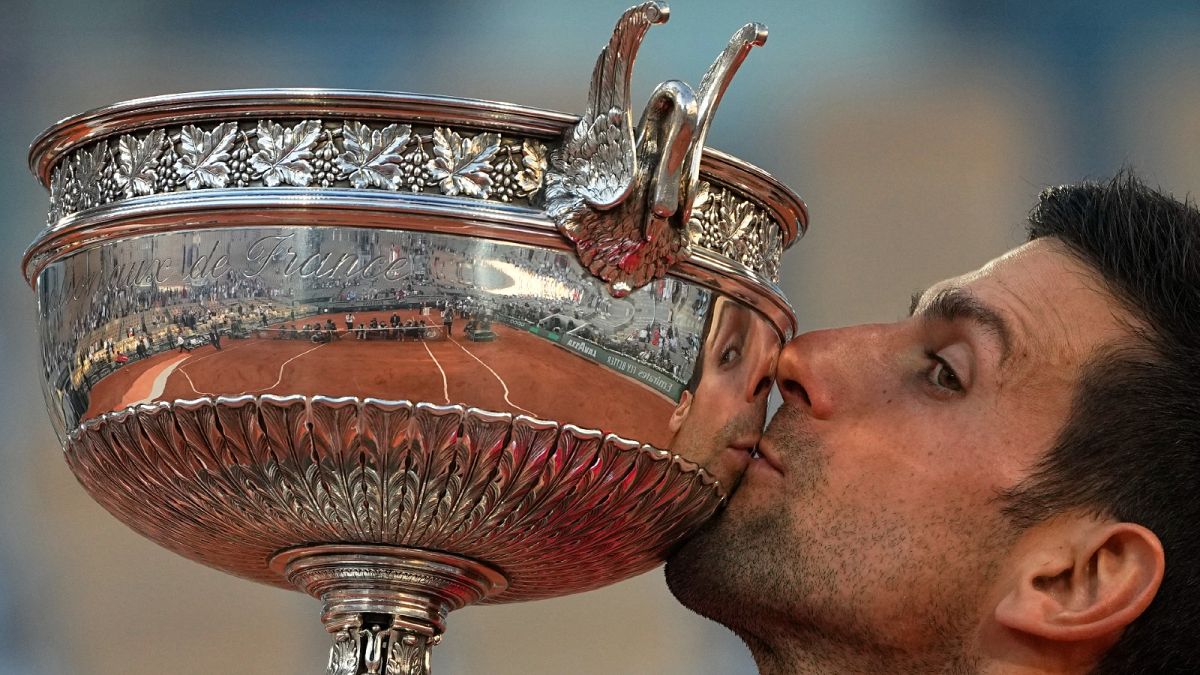 Serbia's Novak Djokovic kisses the cup after defeating Stefanos Tsitsipas of Greece during their final match of the French Open tennis tournament at the Roland Garros stadium 