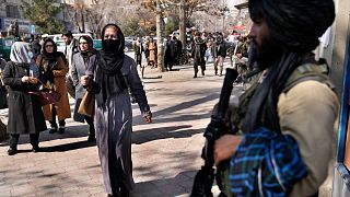 نساء أفغانيات أمام مقاتل من طالبان بأحد شوارع كابول-أفغانستان
