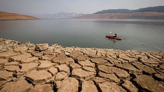 A kayaker paddles in Lake Oroville as water levels remain low due to continuing drought conditions in Oroville, Calif., on Aug. 22