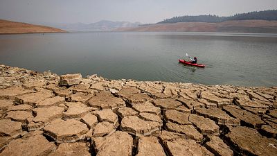 A kayaker paddles in Lake Oroville as water levels remain low due to continuing drought conditions in Oroville, Calif., on Aug. 22
