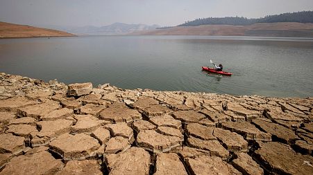 A kayaker paddles in Lake Oroville as water levels remain low due to continuing drought conditions in Oroville, Calif., on Aug. 22