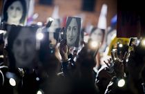 People hold pictures of slain journalist Daphne Caruana Galizia during a 2019 protest.