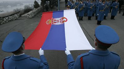 A Serbian army guard of honour raises a Serbian flag, on the eve of Serbian Statehood Day 2008, in Belgrade,