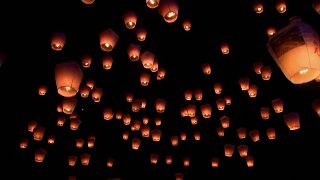 People releasing sky lanterns into the sky.