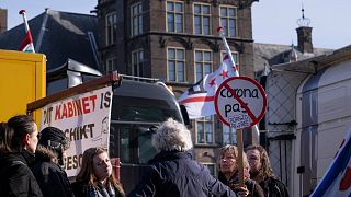 Demonstrators talk next to some of the 20 trucks which blocked one entrance to government buildings to protest COVID measures in The Hague, Netherlands, Feb. 12, 2022.