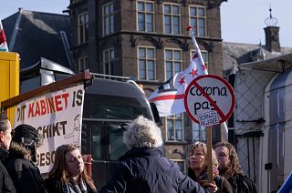 Demonstrators talk next to some of the 20 trucks which blocked one entrance to government buildings to protest COVID measures in The Hague, Netherlands, Feb. 12, 2022.