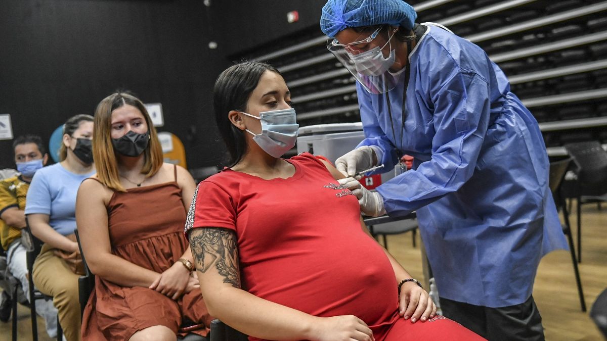 A pregnant woman is inoculated with the Pfizer-BioNTech vaccine against COVID at a vaccination center in Medellin, Colombia.