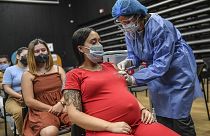 A pregnant woman is inoculated with the Pfizer-BioNTech vaccine against COVID at a vaccination center in Medellin, Colombia.