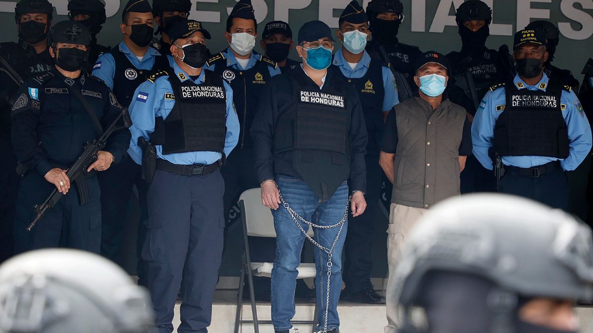 Former Honduran President Juan Orlando Hernandez, centre in chains, is shown to the press at the Police Headquarters in Tegucigalpa, Honduras, Feb. 15, 2022. 